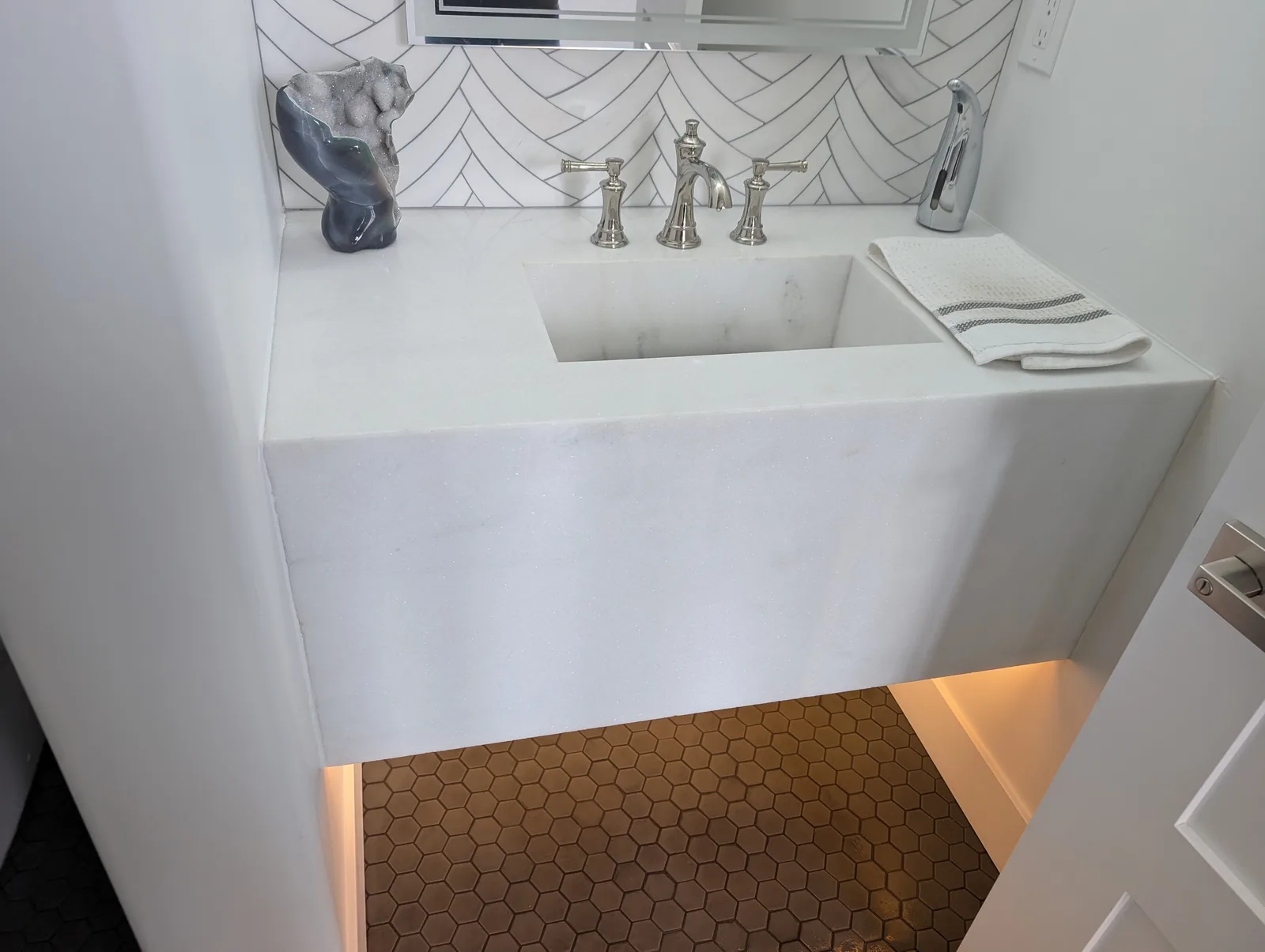 White stone powder room vanity with an integrated basin