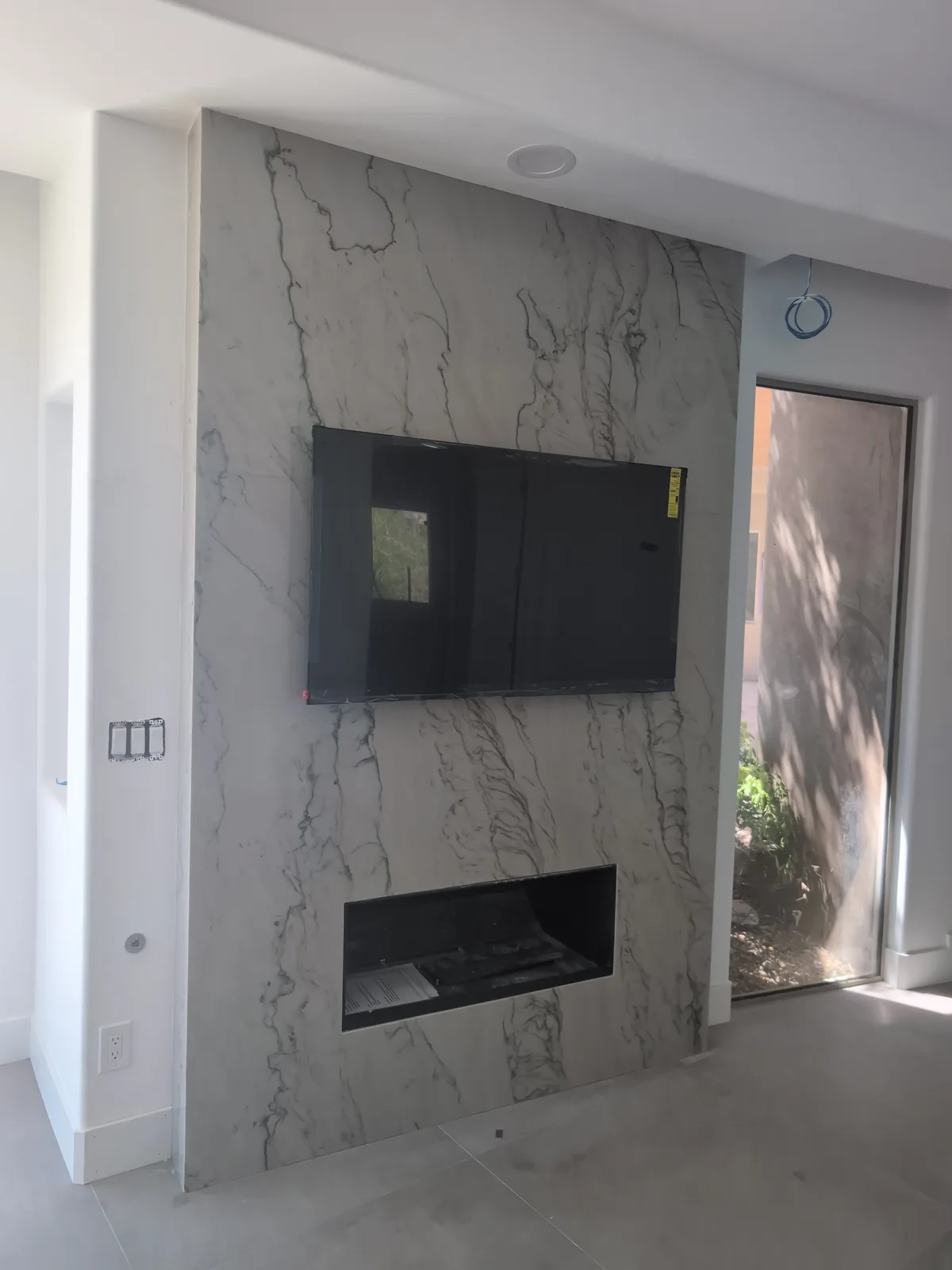 Light veined stone feature wall with an inset fireplace